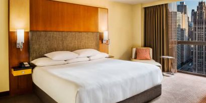 Double bed guest room in Hyatt Regency Chicago, with large window offering views of the urban vista.