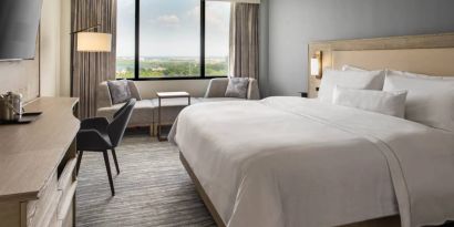 Guest room in the Westin Atlanta Airport Hotel, with large bed and workspace desk and chair.