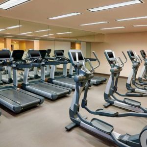 The hotel fitness center is equipped with numerous exercise machines for guests.