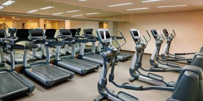 The hotel fitness center is equipped with numerous exercise machines for guests.