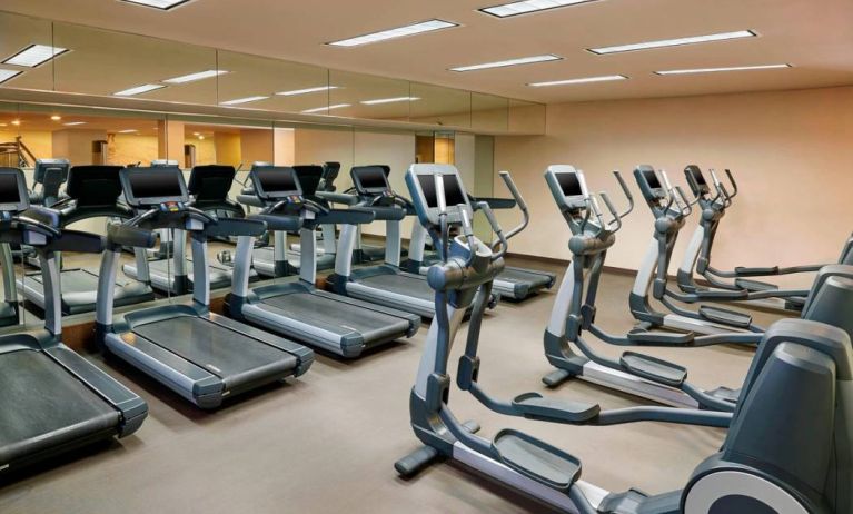 The hotel fitness center is equipped with numerous exercise machines for guests.