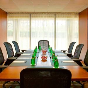 One of Westin Atlanta Airport Hotel’s meeting rooms, with long table, seating for eight, and a large window.