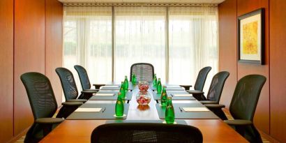 One of Westin Atlanta Airport Hotel’s meeting rooms, with long table, seating for eight, and a large window.