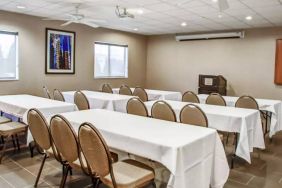 Hotel meeting room with multiple tables arranged facing a lectern.