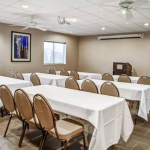 Hotel meeting room with multiple tables arranged facing a lectern.