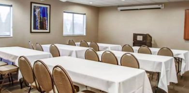 Hotel meeting room with multiple tables arranged facing a lectern.