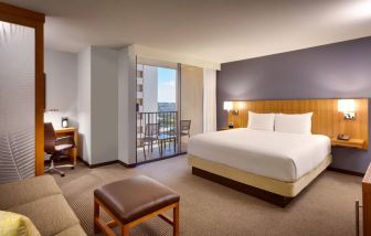 One of Hyatt Place Waikiki Beach’s guest rooms, including double bed and chair/desk for working.