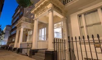 The nocturnal exterior of the Victoria Inn, including stylish white columns.