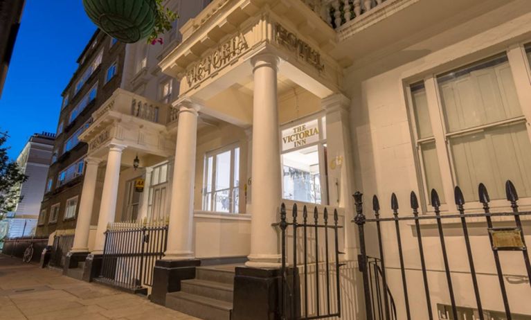 The nocturnal exterior of the Victoria Inn, including stylish white columns.