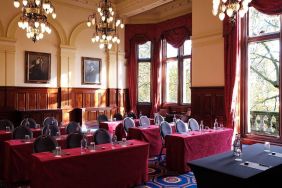 The River Room of The Royal Horseguards Hotel, a meeting space decorated with wood panels and chandeliers.