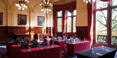 The River Room of The Royal Horseguards Hotel, a meeting space decorated with wood panels and chandeliers.