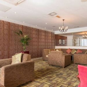 Hotel lounge featuring armchairs and sofas.