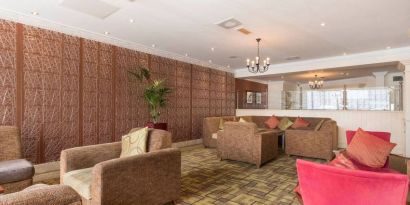 Hotel lounge featuring armchairs and sofas.