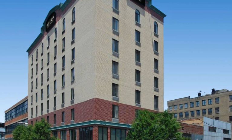 The Red Lion Inn & Suites Long Island City’s exterior, including trees on the sidewalk outside.