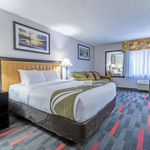 Guest room in Quality Inn Halifax Airport, with sofa, chair, and large window.