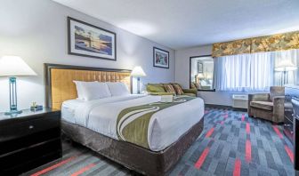 Guest room in Quality Inn Halifax Airport, with sofa, chair, and large window.