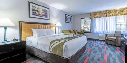 Guest room in Quality Inn Halifax Airport, with sofa, chair, and large window.