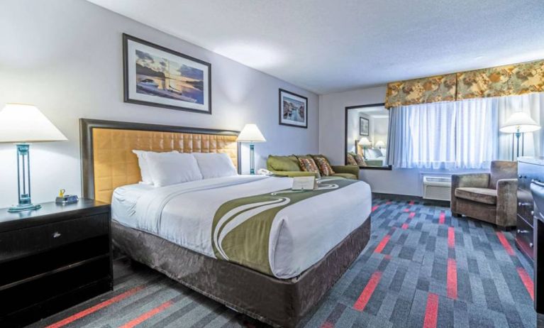 Guest room in Quality Inn Halifax Airport, with sofa, chair, and large window.