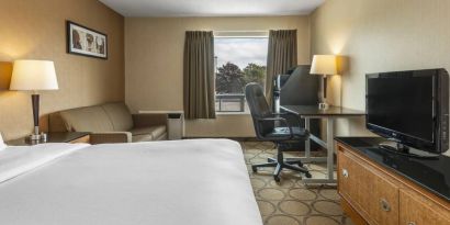 A guest room in the Comfort Inn Regina, with double bed, sofa, and widescreen television.