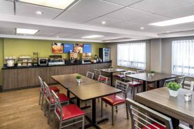 The hotel’s breakfast area has a hard floor and variety of table sizes for diners.