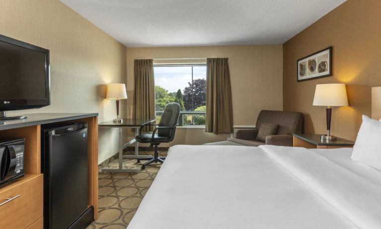 Double bed guest room in Comfort Inn Saskatoon, with window and TV.