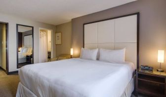 Double bed guest room in Arc The Hotel Ottawa, with bedside lamps and ensuite bathroom.