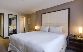 Double bed guest room in Arc The Hotel Ottawa, with bedside lamps and ensuite bathroom.