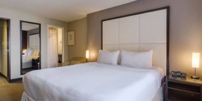 Double bed guest room in Arc The Hotel Ottawa, with bedside lamps and ensuite bathroom.