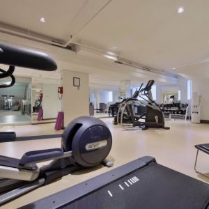 The hotel fitness center has racks of weights and multiple exercise machines.