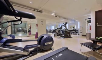 The hotel fitness center has racks of weights and multiple exercise machines.