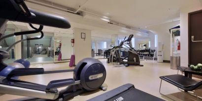 The hotel fitness center has racks of weights and multiple exercise machines.