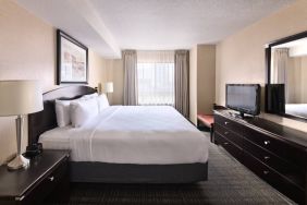 Double bed guest room in Les Suites Hotel Ottawa, with large window and TV.