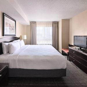 Double bed guest room in Les Suites Hotel Ottawa, with large window and TV.