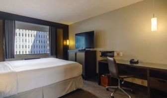 Guest room in Arc The Hotel Ottawa, with a workspace desk and chair, plus armchair and sofa.