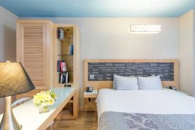 Double bedroom at TRYP By Wyndham Times Square South, including bookcase and lamp.