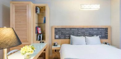 Double bedroom at TRYP By Wyndham Times Square South, including bookcase and lamp.