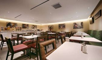 Breakfast venue at the Best Western Premier Herald Square, with small tables and chairs.