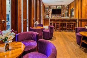 The hotel’s on-site bar, with hard floor and bright purple chairs.