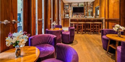 The hotel’s on-site bar, with hard floor and bright purple chairs.