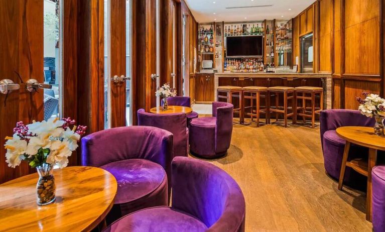 The hotel’s on-site bar, with hard floor and bright purple chairs.