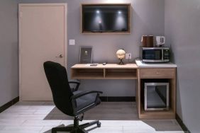 Workspace in a room at the Madison LES Hotel, including desk, chair, and microwave.