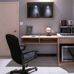 Workspace in a room at the Madison LES Hotel, including desk, chair, and microwave.