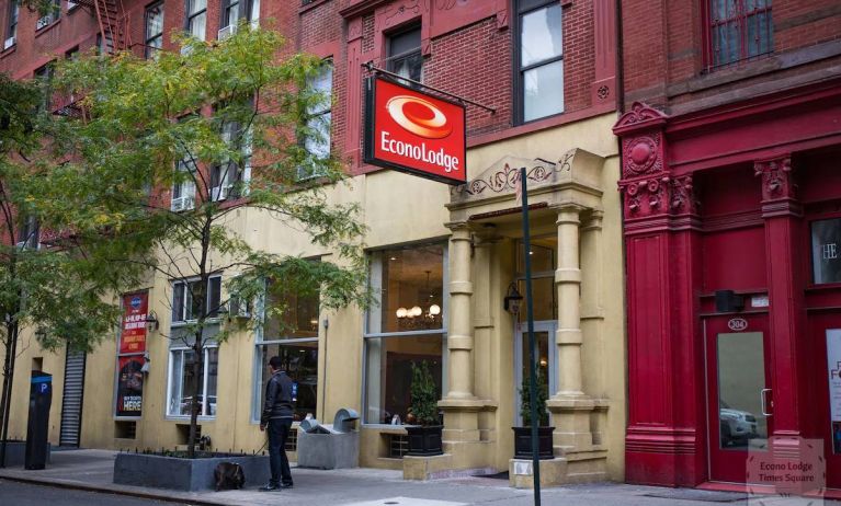 Exterior shot of the Econo Lodge Times Square, with stone awning and nearby tree.