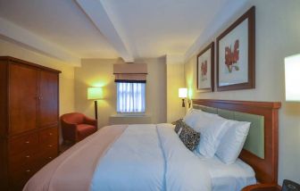 A double bedroom within the San Carlos Hotel, with window and chair.