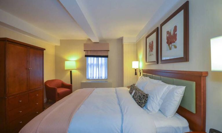 A double bedroom within the San Carlos Hotel, with window and chair.