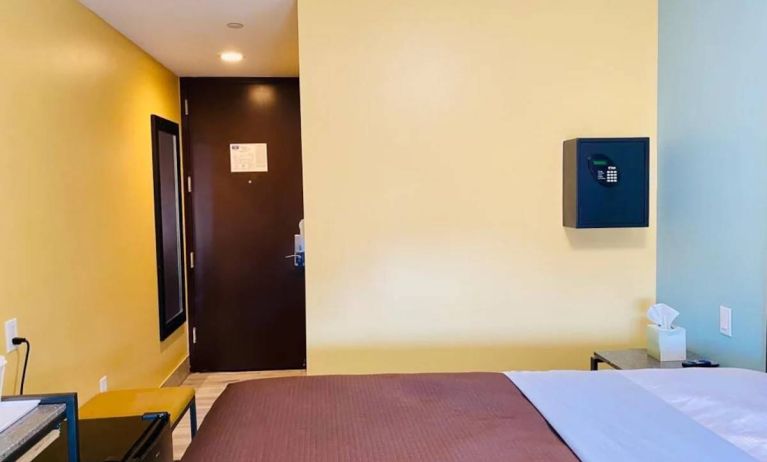 Bedroom at the Rodeway Inn Cranston JFK, with bedside table and wall-mounted safe.