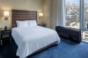 Guest room at the Hilton Fashion District, with double bed and view of the city.