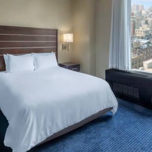 Guest room at the Hilton Fashion District, with double bed and view of the city.