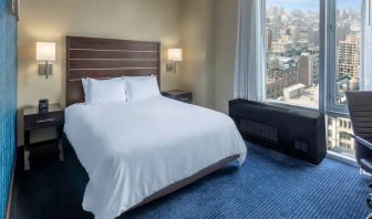 Guest room at the Hilton Fashion District, with double bed and view of the city.