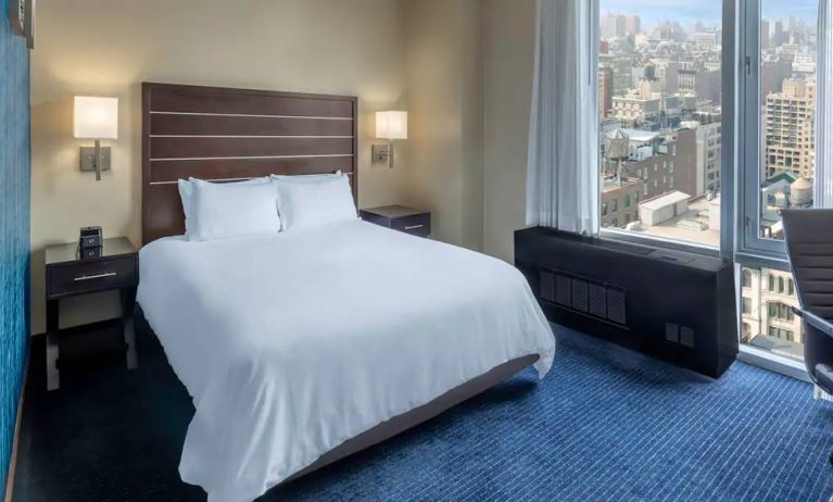 Guest room at the Hilton Fashion District, with double bed and view of the city.